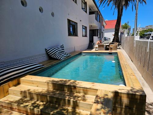 a swimming pool with a wooden deck next to a house at WunderLux in Cape Town