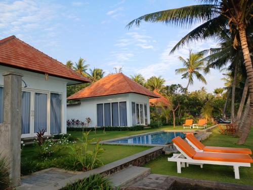 a villa with a swimming pool and a house at Mojito Beach Villas in Kubutambahan