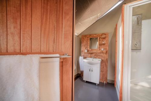 a bathroom with a toilet and a sink at Nkambeni Safari Camp in Hazyview