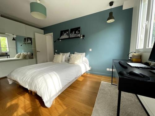 1 dormitorio con 1 cama y escritorio con ordenador en Grand Appartement proche Paris, en Sèvres