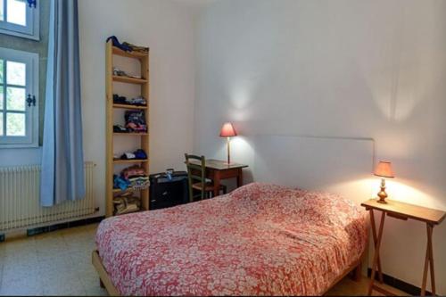 um quarto com uma cama, uma secretária e uma janela em Château Teillan - Cadran solaire em Aimargues
