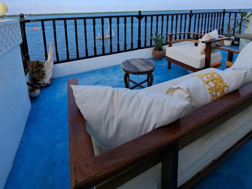 a bed on the balcony of a house at Pwani House - Lamu Seafront in Lamu