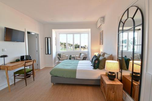 a hotel room with a bed and a desk and a desk at ArchiSuites in Coimbra