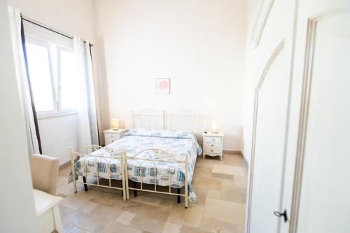 - une chambre blanche avec un lit et une fenêtre dans l'établissement Agriturismo "Il Vignale", à Ostuni