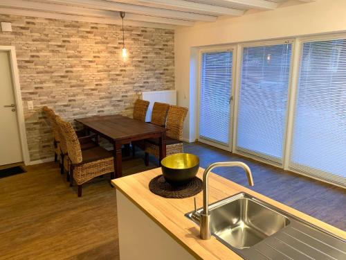 a kitchen with a sink and a table with a dining room at Ferienwohnungen Arp "Beach House" mit Terrasse und Parkplatz in Itzehoe