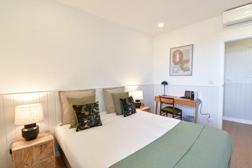 a bedroom with a large bed and a desk at ArchiSuites in Coimbra