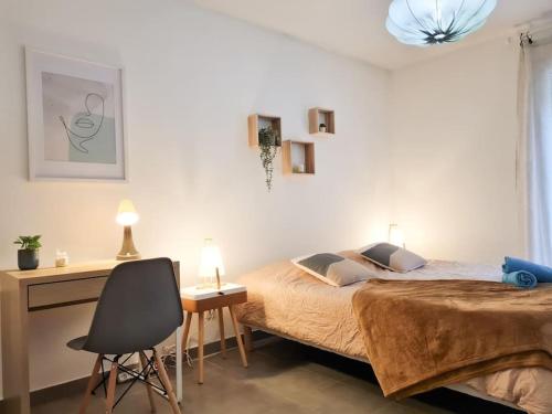 a bedroom with a bed and a desk and a chair at Appartement avec parking privé et terrasse proche Nice/Monaco in La Trinité