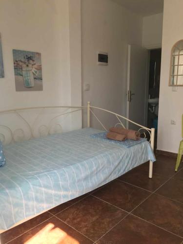 a small bed in a room with a blue sheet at Maria Apartments in Néa Karváli
