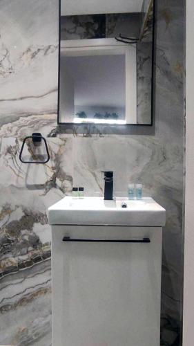 a bathroom with a white sink and a mirror at FLUMEN HOUSE - Studio Apt - Trikala in Tríkala