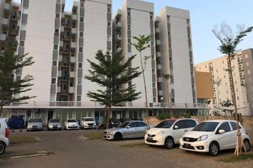 a parking lot with cars parked in front of a building at Barata Residence Aeropolis in Tangerang