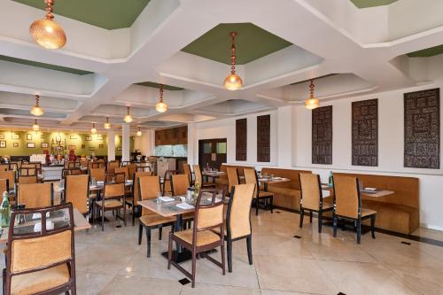 a dining room with tables and chairs and lights at Sterling Mount Abu in Mount Ābu