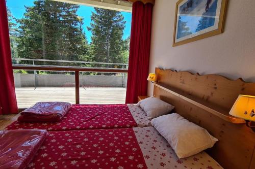 Schlafzimmer mit einem Bett und einem Fenster in der Unterkunft Chamrousse, 50m piste, wifi +, terrasse vue sapins in Chamrousse
