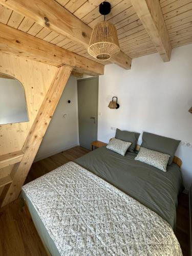 une chambre avec un lit dans une pièce avec des plafonds en bois dans l'établissement Appartement le StelO Les Gets 6 personnes aux pieds des pistes 2 chambres, aux Gets