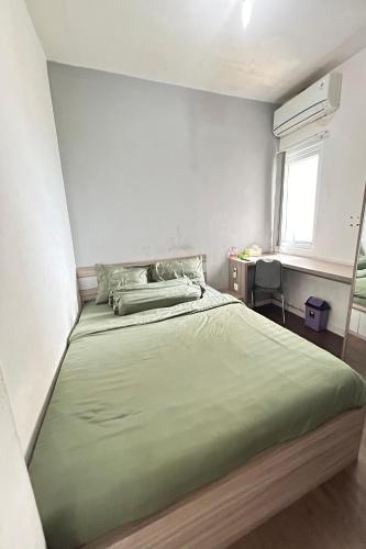 a bedroom with a large green bed with a window at Barata Residence Aeropolis in Tangerang
