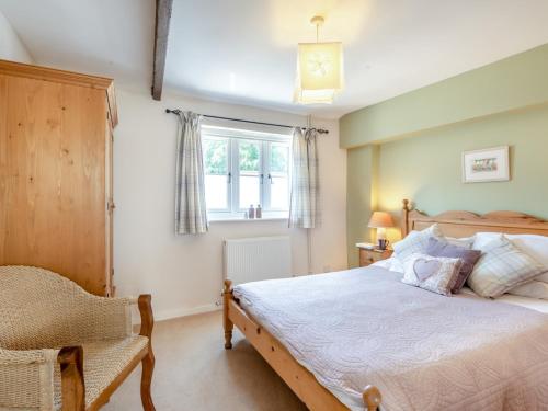 a bedroom with a bed and a chair and a window at 2 Bed in Reepham 37016 in Cawston