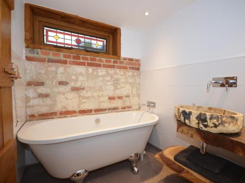 een badkamer met een wit bad en een raam bij 2 Bed in Dorchester 41364 in Ansty