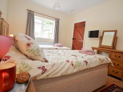 a bedroom with a bed with a floral bedspread at 1 Bed in Barnstaple 40352 in Chapelton