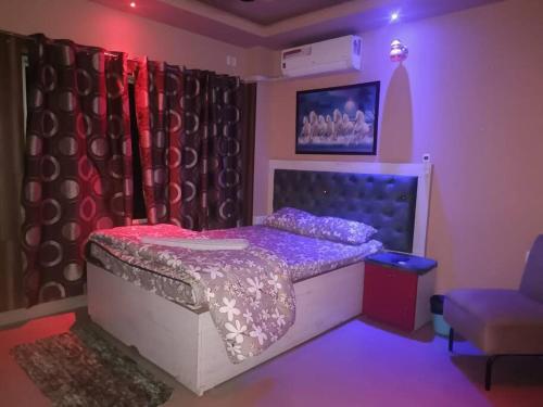 sypialnia z łóżkiem, krzesłem i zasłonami w obiekcie Your Right Place w mieście Guwahati