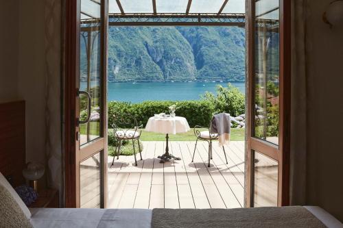a bedroom with a door open to a patio with a table at Hotel Belvedere in Bellagio