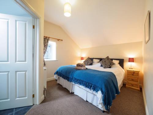 a bedroom with a bed with a blue blanket at 3 Bed in Eyam PK833 in Eyam