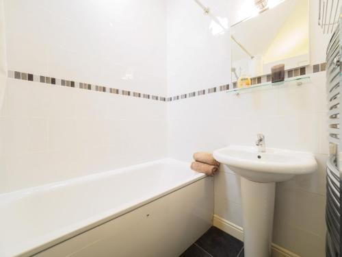 a white bathroom with a sink and a bath tub at 3 Bed in Eyam PK833 in Eyam