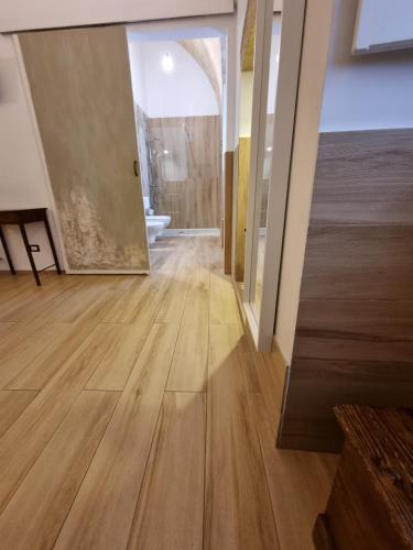 an empty room with wooden floors and a large mirror at B&B Novecento Italiano in Altamura