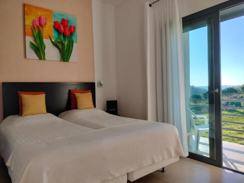 a bedroom with two beds and a large window at Casa Ceedina Bed And Breakfast & Beauty in Batalha