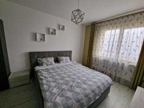 a bedroom with a bed and a window at Gray apartment nearby Amethyst & Vivo Mall in Floreşti