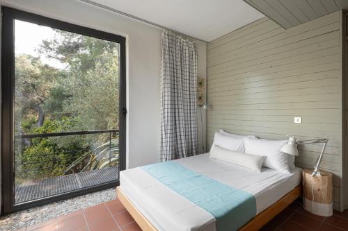 a bedroom with a bed and a large window at Blue Ivy Pool Villa #FeelsLikeHome in Vourvourou
