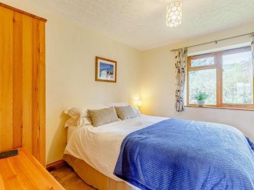 a bedroom with a bed with a blue blanket at 2 Bed in Worcester CC071 in Clifton upon Teme
