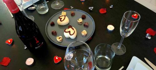 a table with a plate of desserts and wine glasses at Charda Spa in Seyne