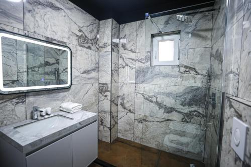 een badkamer met een wastafel en een douche bij Miku Apartment-Extraordinary 1BD At Komuna e Parisit in Tirana