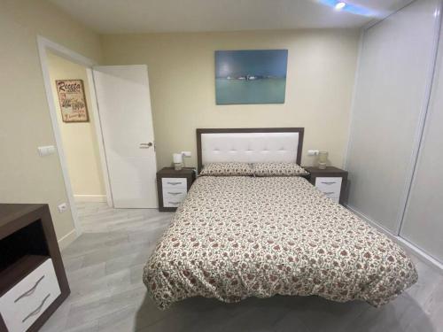 a bedroom with a large bed and two night stands at La casa de las Flores in Ponferrada