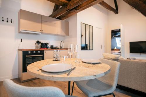 kuchnia i jadalnia z drewnianym stołem i krzesłami w obiekcie Le Laurencin Sens - L Authentique w mieście Sens