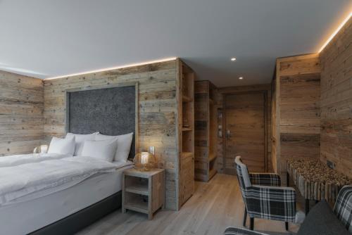 a bedroom with a large bed and wooden walls at Caschu Alp Boutique Design Hotel Stoos - adults only in Stoos