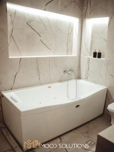 a white bath tub in a bathroom with a mirror at FirstLineSkg3 Moodsolutions Living in Thessaloniki