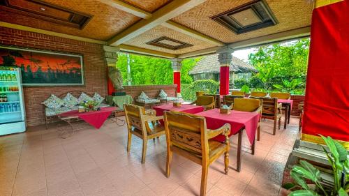 ein Restaurant mit rosa Tischen und Stühlen auf einer Terrasse in der Unterkunft Garden View Ubud in Ubud