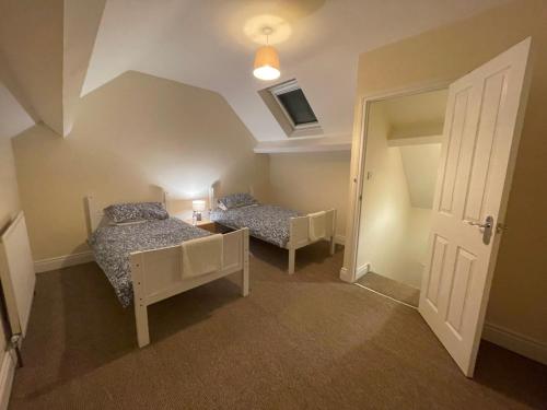 Kleines Zimmer mit 2 Betten und einer Tür in der Unterkunft Hillview House in Belfast