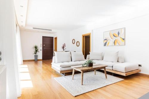 a living room with white couches and a coffee table at 3 Bed luxury apartment with pool in Glyfada in Athens