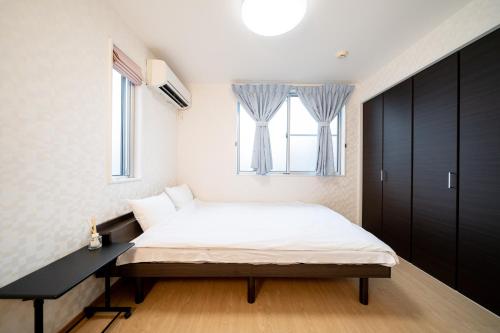 um quarto com uma cama e uma janela em Shinokubo guest house em Tóquio