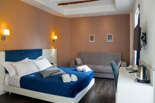 a bedroom with a blue bed and a couch at Palazzo Cappuccini Art Relais in Naples