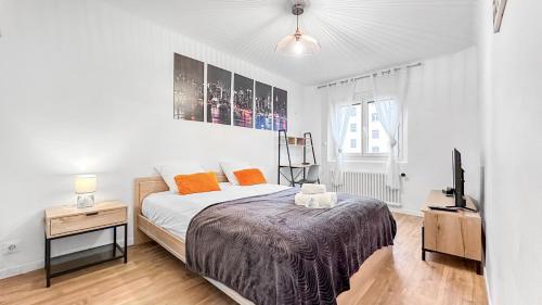 een slaapkamer met een bed en een televisie. bij COLOC PASTEUR - Belle colocation de 3 chambres - Hypercentre - Proche Gare et Tram - Wifi gratuit in Annemasse