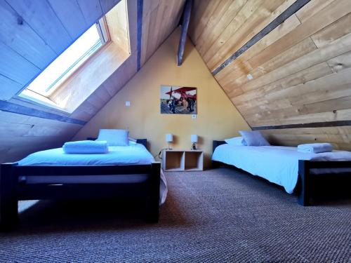 - une chambre mansardée avec 2 lits et une fenêtre dans l'établissement Maison de vacances 9 personnes avec piscine, à Saint-Amand-de-Coly