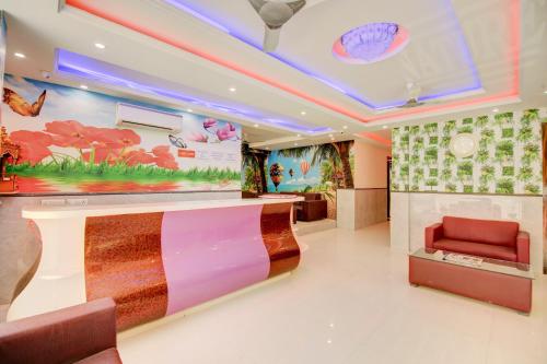 a lobby with a waiting area with a red chair at Hotel Smart Signature Delhi Airport in New Delhi