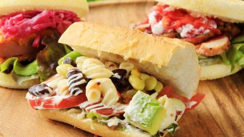 two sandwiches with pasta and vegetables on a table at QuintessaHotel KagoshimaTenmonkan Relax&Sleep in Kagoshima