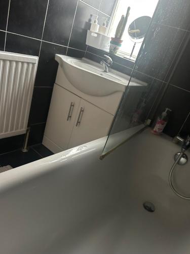 a bathroom with a tub and a sink and a mirror at Bright Master Bedroom Saturn in London