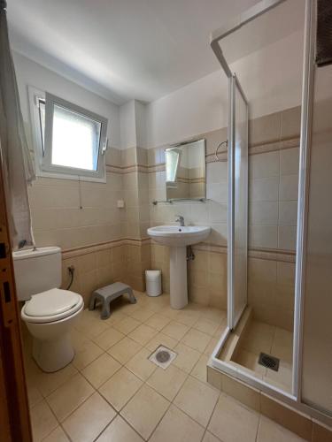 uma casa de banho com um WC, um lavatório e um chuveiro em Villa Eros em Zóla