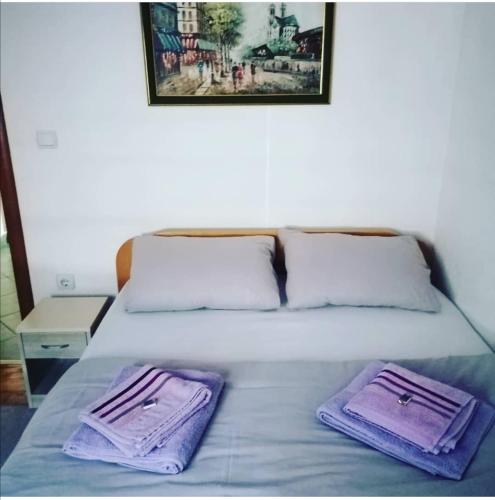 - un lit avec 2 serviettes violettes dans l'établissement Apartman Miloš na Kopaoniku, à Raška