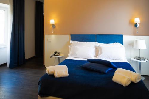 a bedroom with a blue bed with white pillows at Palazzo Cappuccini Art Relais in Naples