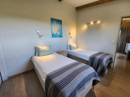 Zimmer mit 2 Betten in einem Zimmer in der Unterkunft Caracal Cottage in Plettenberg Bay